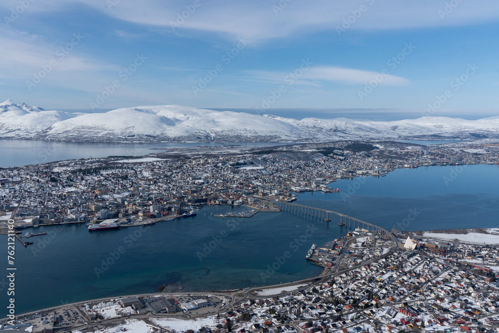 ​The Arctic winter landscape view of Tromso and its surrounding mountains, fjord, islands, Tromsø Bridge, and Arctic Cathedral from the Storsteinen mountain, Tromsø, Norway