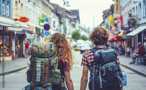 Two young backpackers couple traveling through cities in Europe, view from the back.