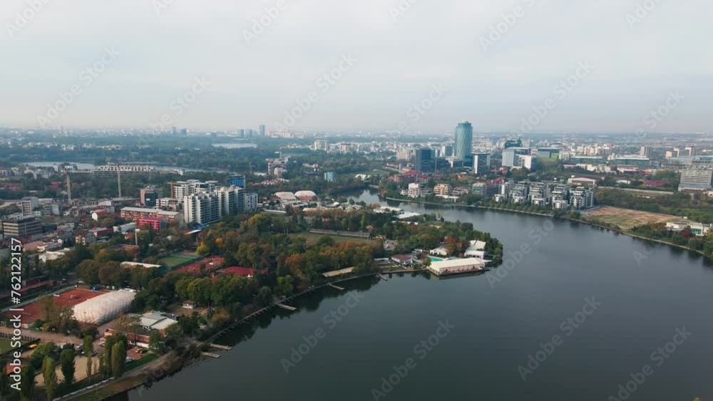 Floreasca lake with bucharest skyline, serene waters, urban landscape, cloudy day, cityscape backdrop, aerial view Floreasca lake with bucharest skyline, serene waters, urban landscape, cloudy day, cityscape backdrop, aerial view