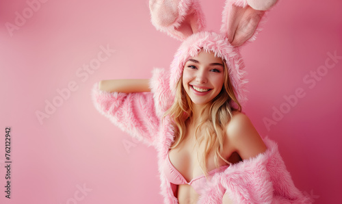 Sexy young woman in fur bunny costume on pink background