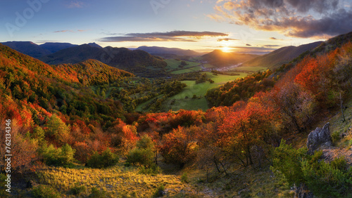Mountains at sunset in Slovakia. Landscape with mountain hills orange trees and grass in fall, colorful sky with golden sunbeams. Panorama photo