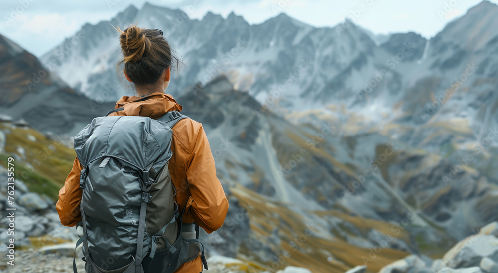 a woman with backpack hiking in the mountains