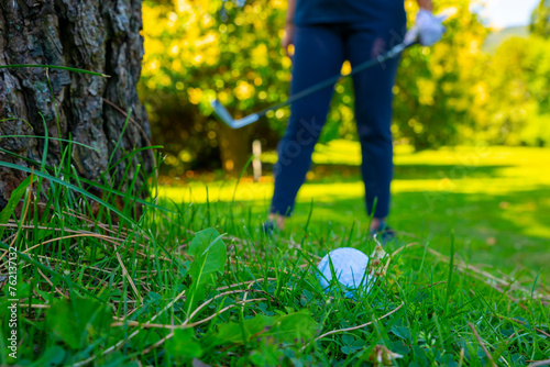 Wallpaper Mural Golf Ball Lying on the Rough Grass and Golfer with Golf Club Searching for the Golf Ball in the Trees in a Sunny Day in Switzerland. Torontodigital.ca