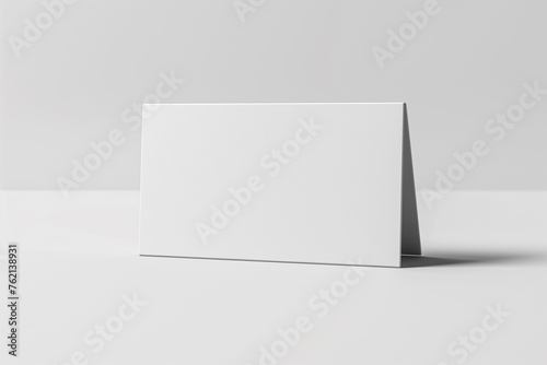 A blank, folded white card rests on a table