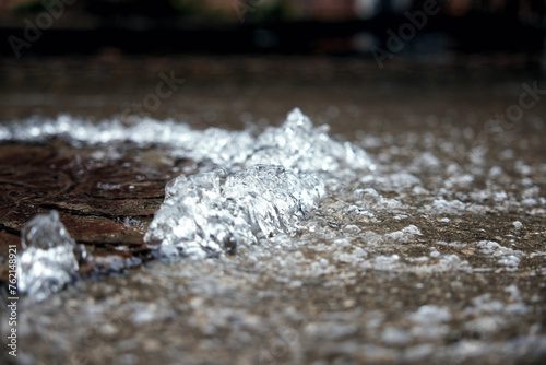 Water pipe burst, water Water flows out of the manhole onto the asphalt. The accident in the sewer. Leaking water supply system in the city on the road