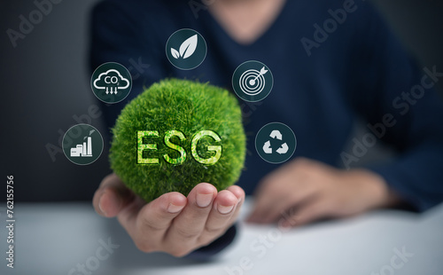 A person is holding a green ball with the letters ESG on it