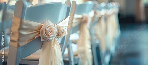 The gesture of decorating a row of chairs with ribbons and flowers for a wedding ceremony is an artful touch to the event. The electric blue ribbons add a pop of color to the room