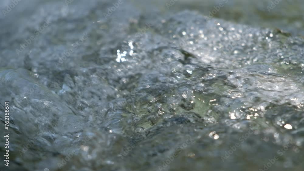 Closeup.The water flows so quickly in the stream that many air bubbles form. Closeup.The water flows so quickly in the stream that many air bubbles form.