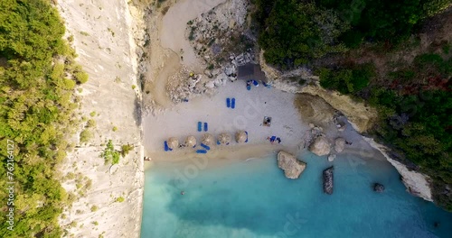 Retreating overhead drone shot, pulling away from the secluded beachfront of Xigia, showing the rock-sheltered cove and the sulphureous waters in Zankynthos Island in Greece. photo