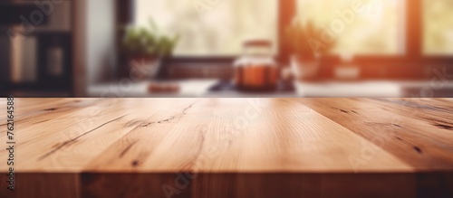 A houseplant sits on a hardwood table with wood stain in the foreground, while sunlight filters through a window in the background