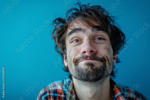 The man makes a funny face. Funny funny portrait of a man on a blue background