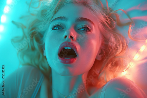 portrait of sexy blonde girl lying on bed having an orgasm while having sex in bedroom photo
