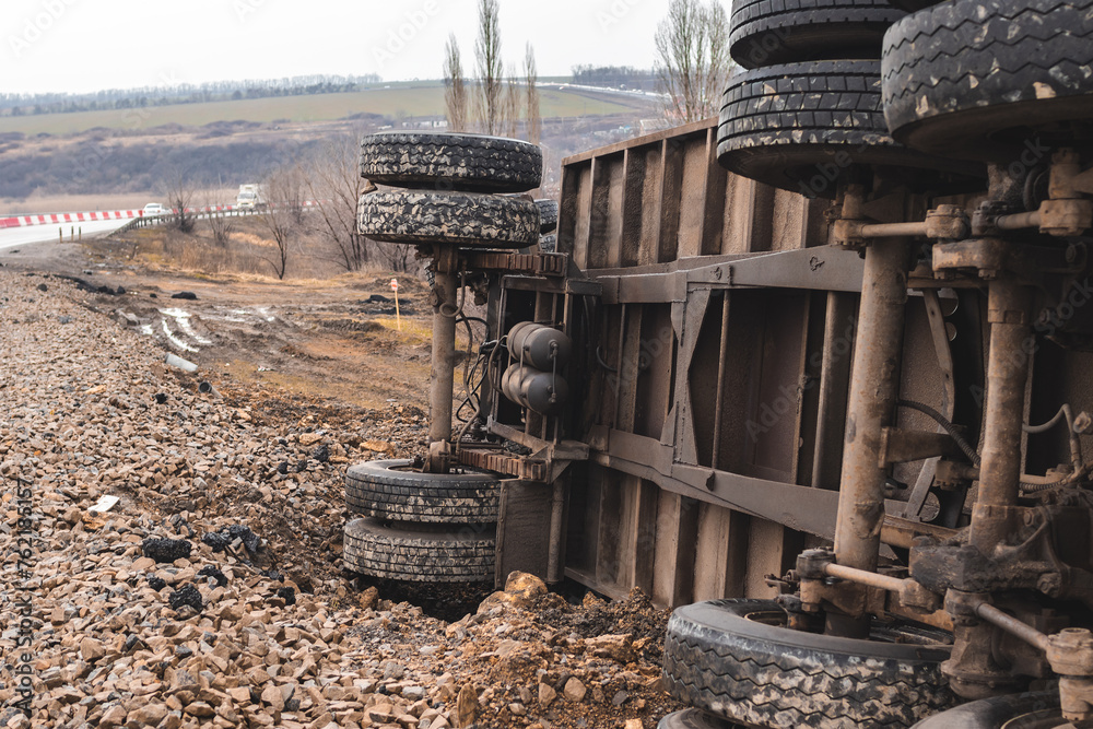 Fototapeta premium The large truck lies in a side ditch after the road accident