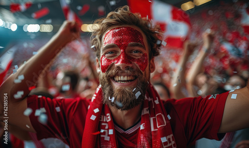 Vibrant Portrait of a Joyful male Denmark Supporter with a Denmark Flag Painted on His Face, Celebrating at UEFA EURO 2024 photo