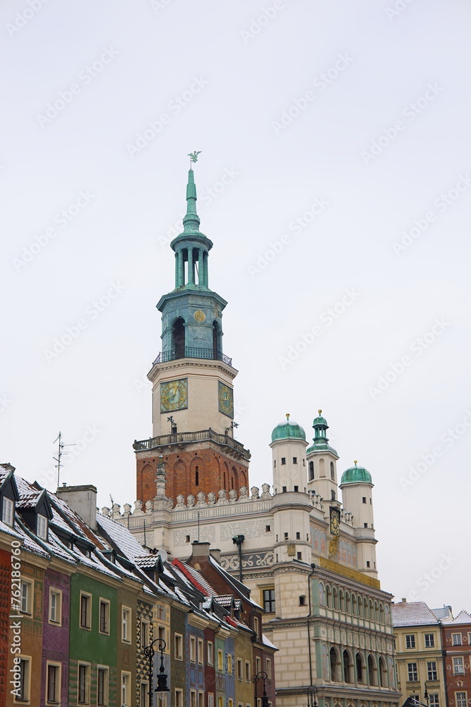 A winter scene of Poznań's old market square captured in January. Snow-covered roofs, the iconic town hall, and clear skies.