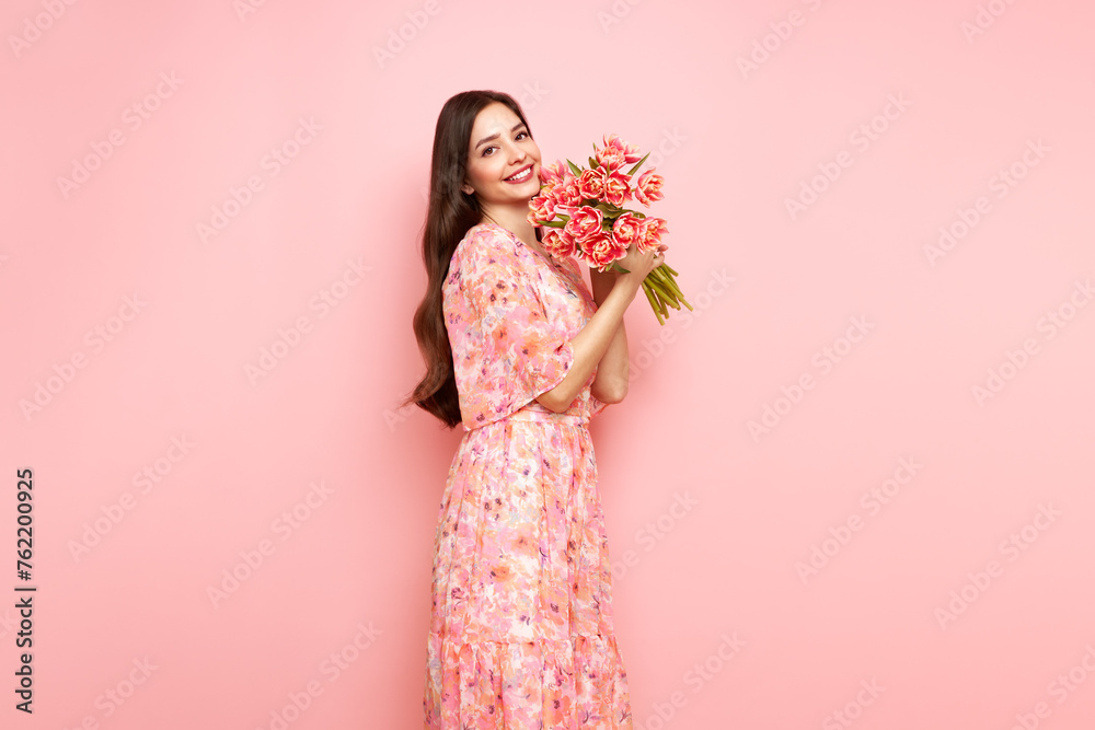 Happy beauty woman with pink tulip bouquet on light pink background. 8th of March celebration Happy beauty woman with pink tulip bouquet on light pink background. 8th of March celebration