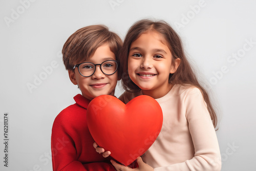 A boy and a girl hold a red shape heart in their hands isolated over white background. Siblings day. generative AI