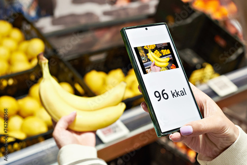 Checking calories on banana in store with smartphone