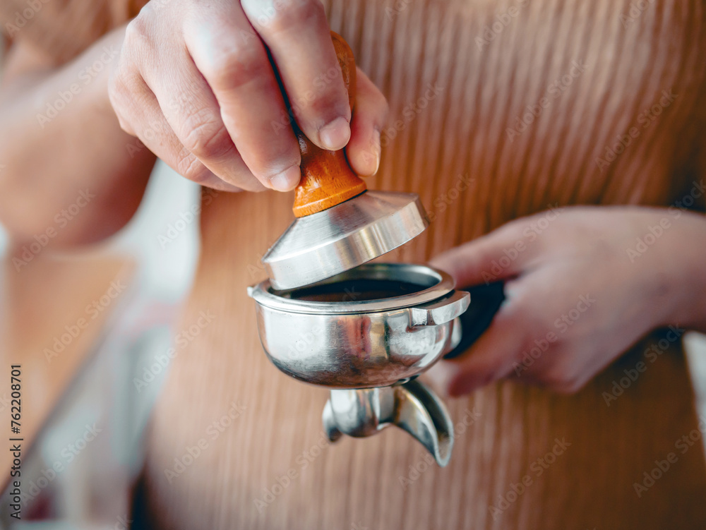Close-up of hand Barista cafe making coffee with manual presses ground coffee using tamper at the coffee shop Close-up of hand Barista cafe making coffee with manual presses ground coffee using tamper at the coffee shop