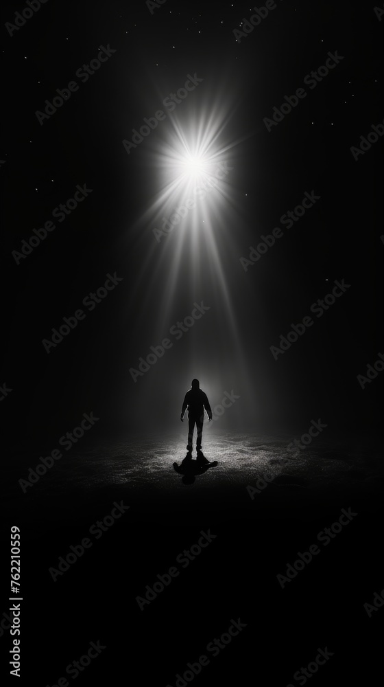 Person Standing Under Bright Light in Dark