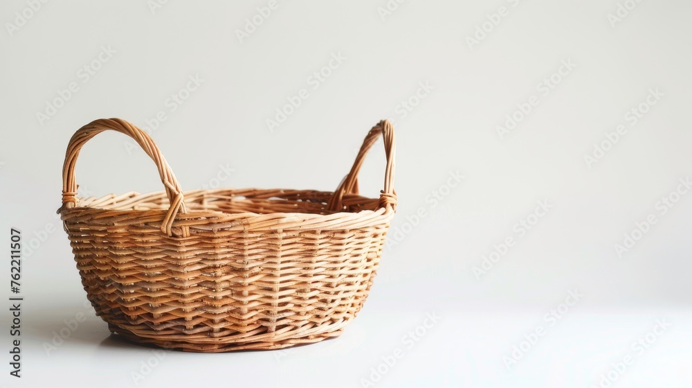 A vacant wicker basket equipped with handles, showcased in isolation against a white background A vacant wicker basket equipped with handles, showcased in isolation against a white background