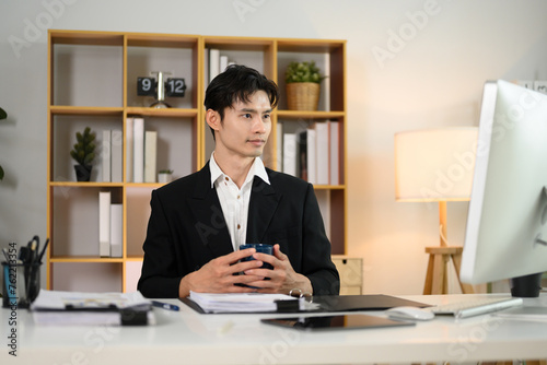 Successful businessman in black suit working at his office