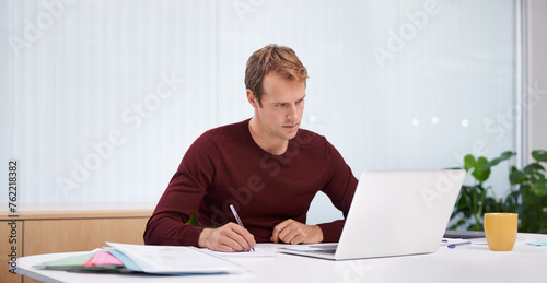 Businessman, laptop and writing notes in office as digital designer for online project, research or paperwork. Male person, career and creative agency with documents for planning, startup or internet