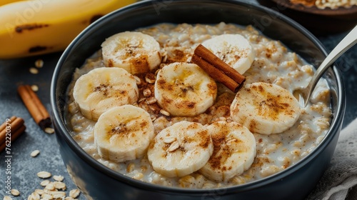 A bowl of oatmeal topped with sliced bananas and a sprinkle of cinnamon.