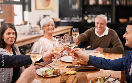 Cheers, champagne and family at dinner in dining room for party, celebration or event at modern home. Smile, toast and group of people enjoying meal, supper or lunch together with wine at house.