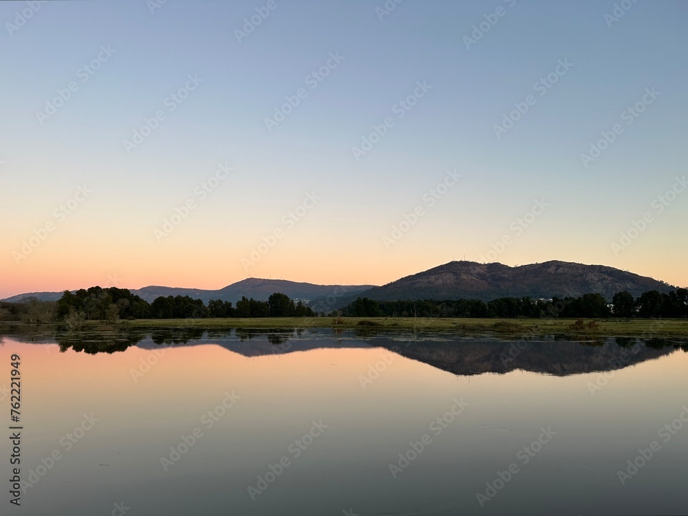 Reflection of a mountain and sunset skies in the water of river Minho near Tabagón, O Rosal, Galicia, Spain, January 2023