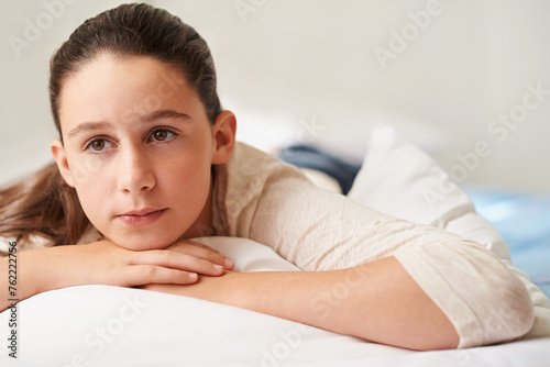 Girl, relax and thinking on bed in home, tired and peace or calm for waking up on weekend. Female person, pillow and comfortable in bedroom for fatigue or contemplating, blanket and ponder for lazy