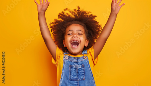 a child cheering with hands up in the air © The Stock Photo Girl