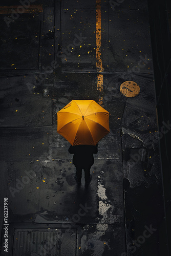 A person holding a yellow umbrella standing on a street