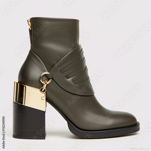 Stylish green boot with a gold accent heel. photo
