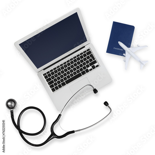 Top view of passport with airplane, computer and a stethoscope isolated on white background, medical insurance travel concept whether it's a summer beach vacation or a business trip. Health and safety