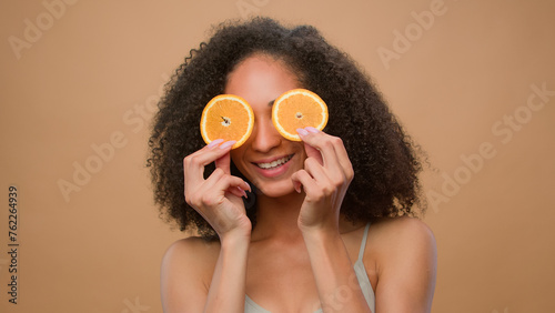 Beauty African American girl woman hold two half orange slices cover eyes dieting vegetarian body weight eco healthy vitamin skin hair care curls shampoo fruit natural organic vegan citrus cosmetic