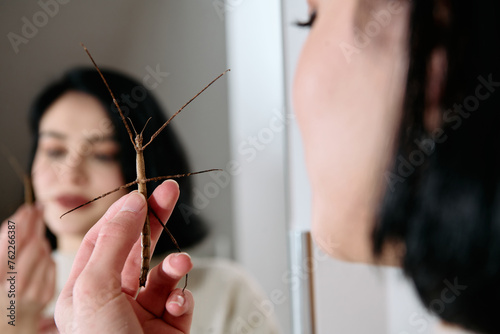 Young Woman Captured in a Beautiful Moment with Her Stick Insect (Medauroidea Extradentata)