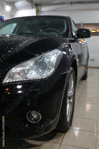 Front of black car with detergent drops during washing © Pavel Losevsky
