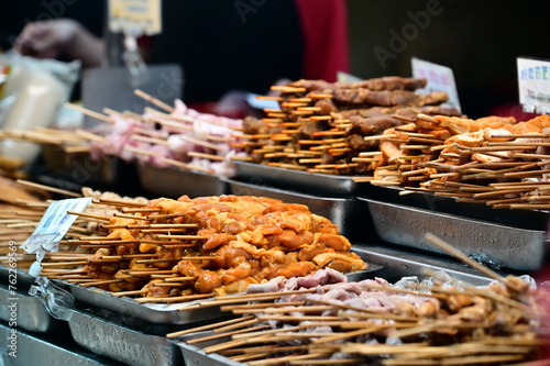 Taiwan - Mar 16, 2024: At Nanjichang Night Market, a stall sells grilled food. Close-up of various marinated meat skewers. Grilled delicacies are common street food at Taiwan night markets. photo