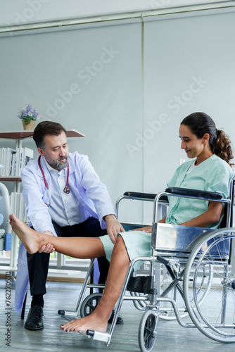 Practitioner assists patient with leg stretch  aiding mobility  in a well-equipped therapeutic space. Expert aids in patient s lower limb rehabilitation  illustrating physical therapy technique 