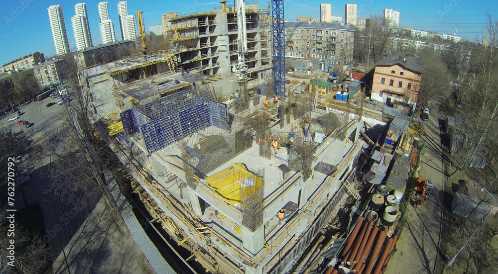 Workers at the construction site of residential building, aerial view