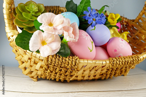 Easter Eggs in the basket with bakery cake fresh baked on white wooden table background