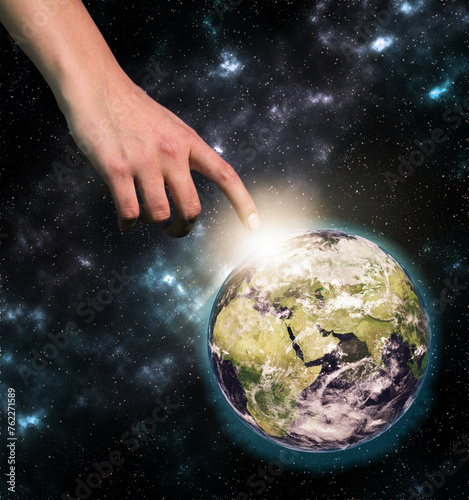 Female hand reaching out to the globe in space, collage. Elements of this image furnished by NASA