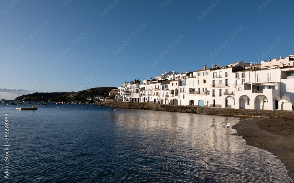 Morning sun illumitates white buildings on the bay of a small Spanish town