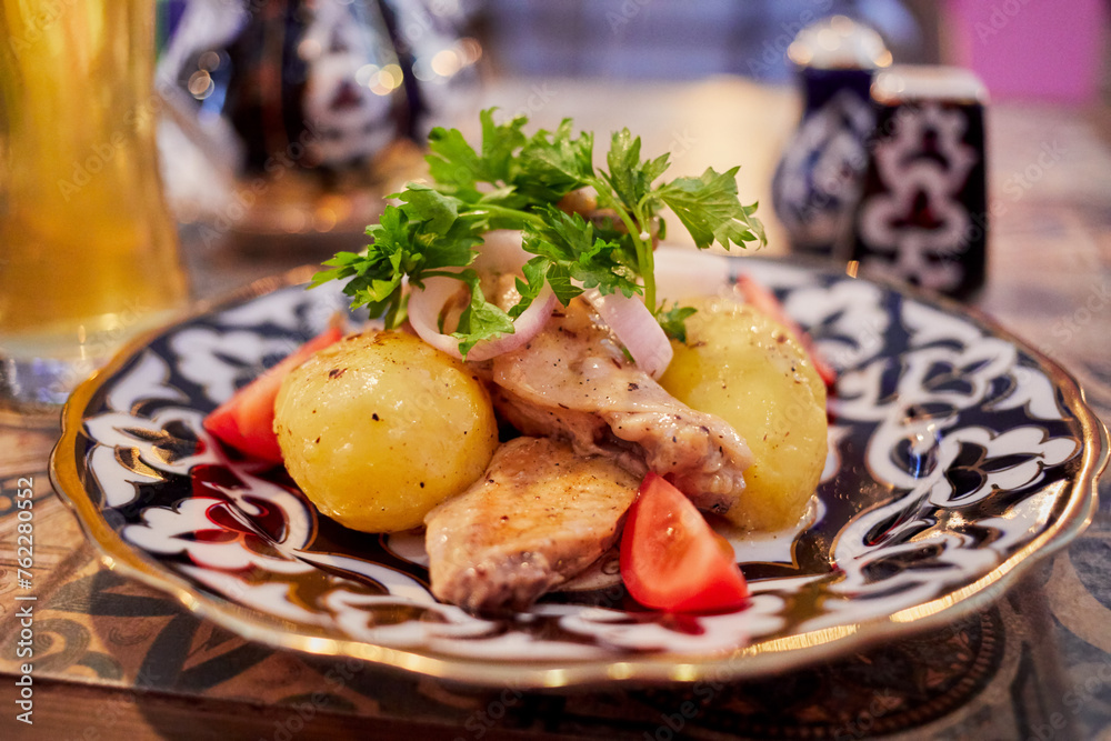 Closeup plate with baked potatoes, meat and fresh vegetables on table. Closeup plate with baked potatoes, meat and fresh vegetables on table.