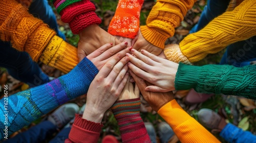 Top view of hands with colorful sleeves, creating a vibrant tapestry of teamwork and unity