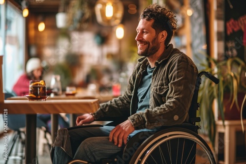 A young man in a wheelchair in cafe among people, actively spending time with friends
