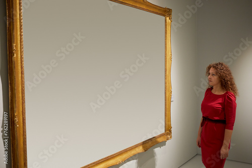 Woman looks at canvas in frame. photo