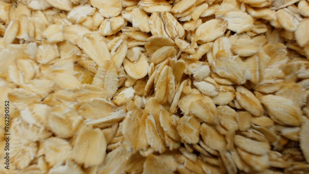 Uncooked oatmeal flakes texture close up. Rotation. Pile of uncooked ...