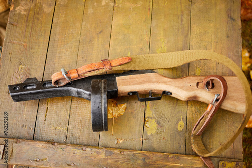 Model of Shpagin submachine gun lying on wet gun-case.